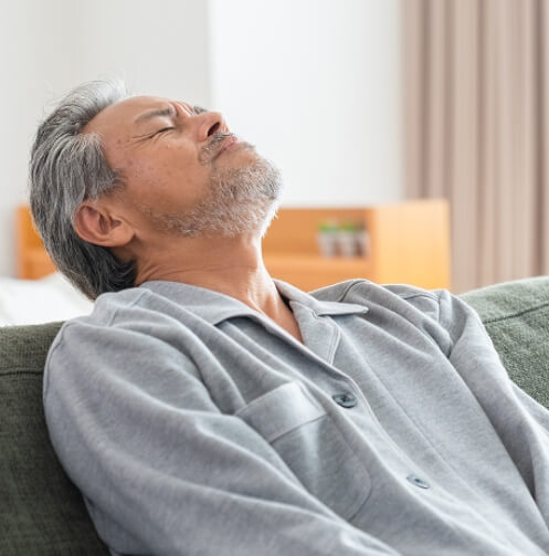 Older man leaning back with eyes closed